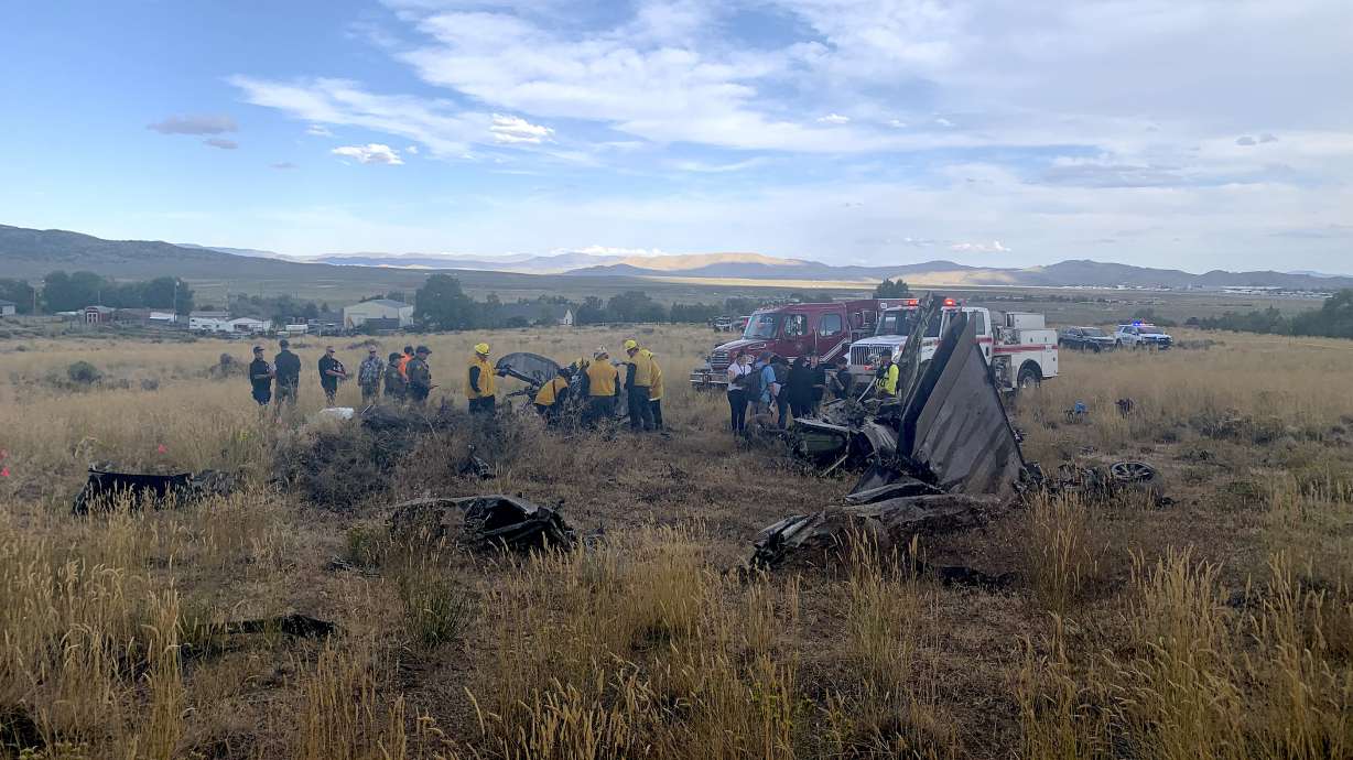 In this photo provided by the Truckee, Calif., Meadows Fire and Rescue Department, members of the Truckee Meadows Fire and Rescue Department and other officials look over aircraft wreckage, Sunday, Sept. 17, 2023, in Reno, Nev., after two California pilots were killed when their planes collided in mid-air while preparing to land after completing a race at the National Championship Air Races north of Reno.