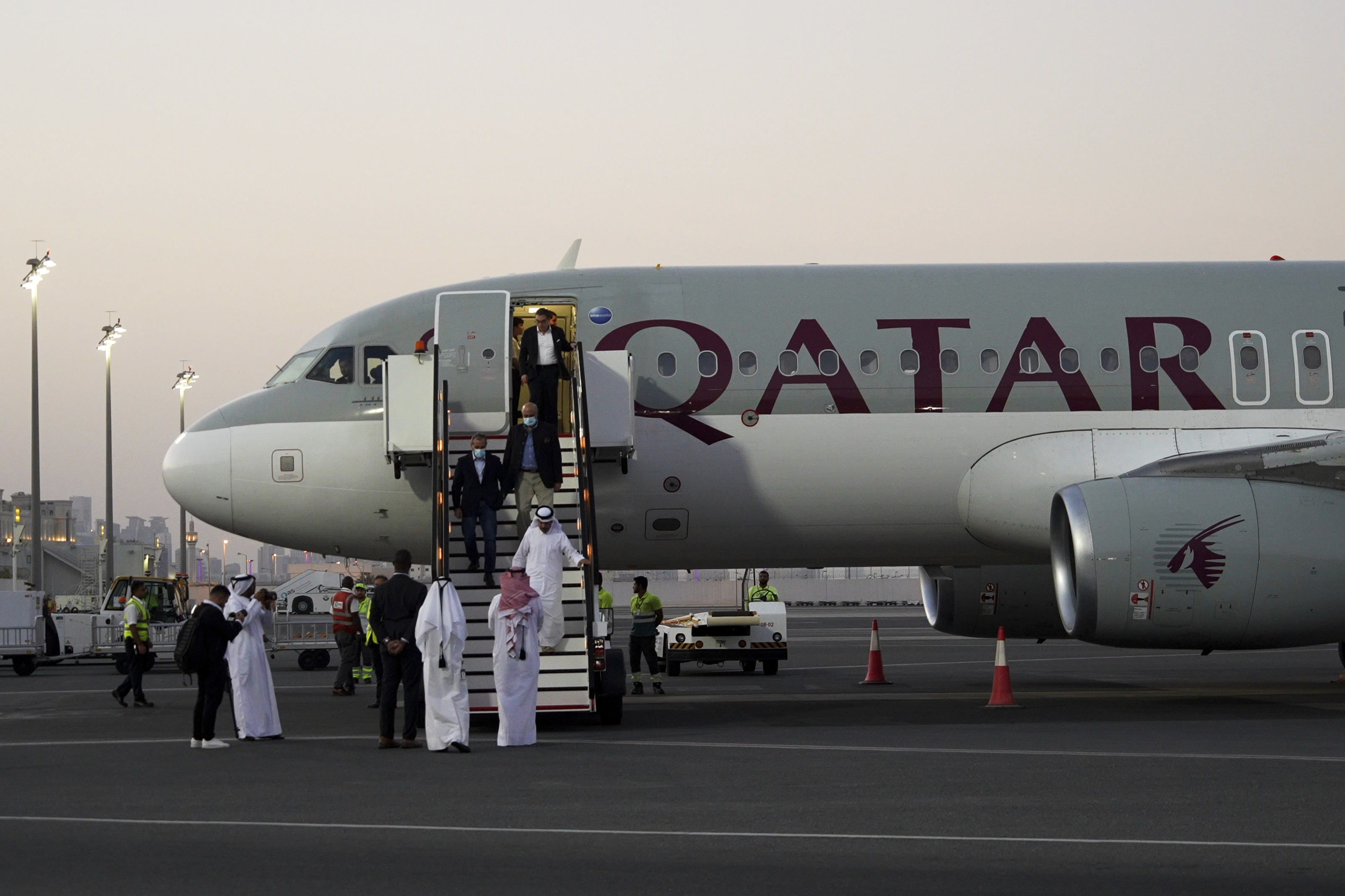 Emad Sharghi, Morad Tahbaz and Siamak Namazi, former prisoners in Iran, walk out of a Qatar Airways flight that brought them out of Tehran and to Doha, Qatar, Monday.