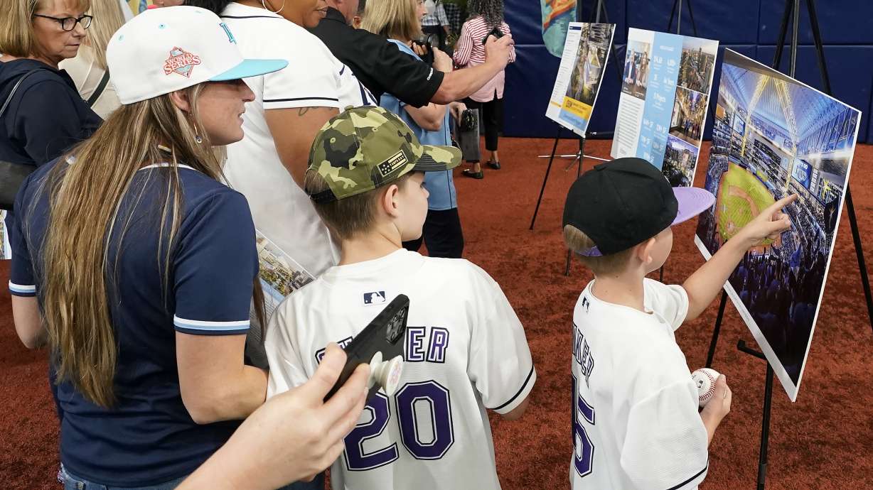 Invited guests look at artist renderings of what the planned Tampa Bay Rays stadium will look like after the team announced plans for a new stadium during a news conference Tuesday, Sept. 19, 2023, in St. Petersburg, Fla.