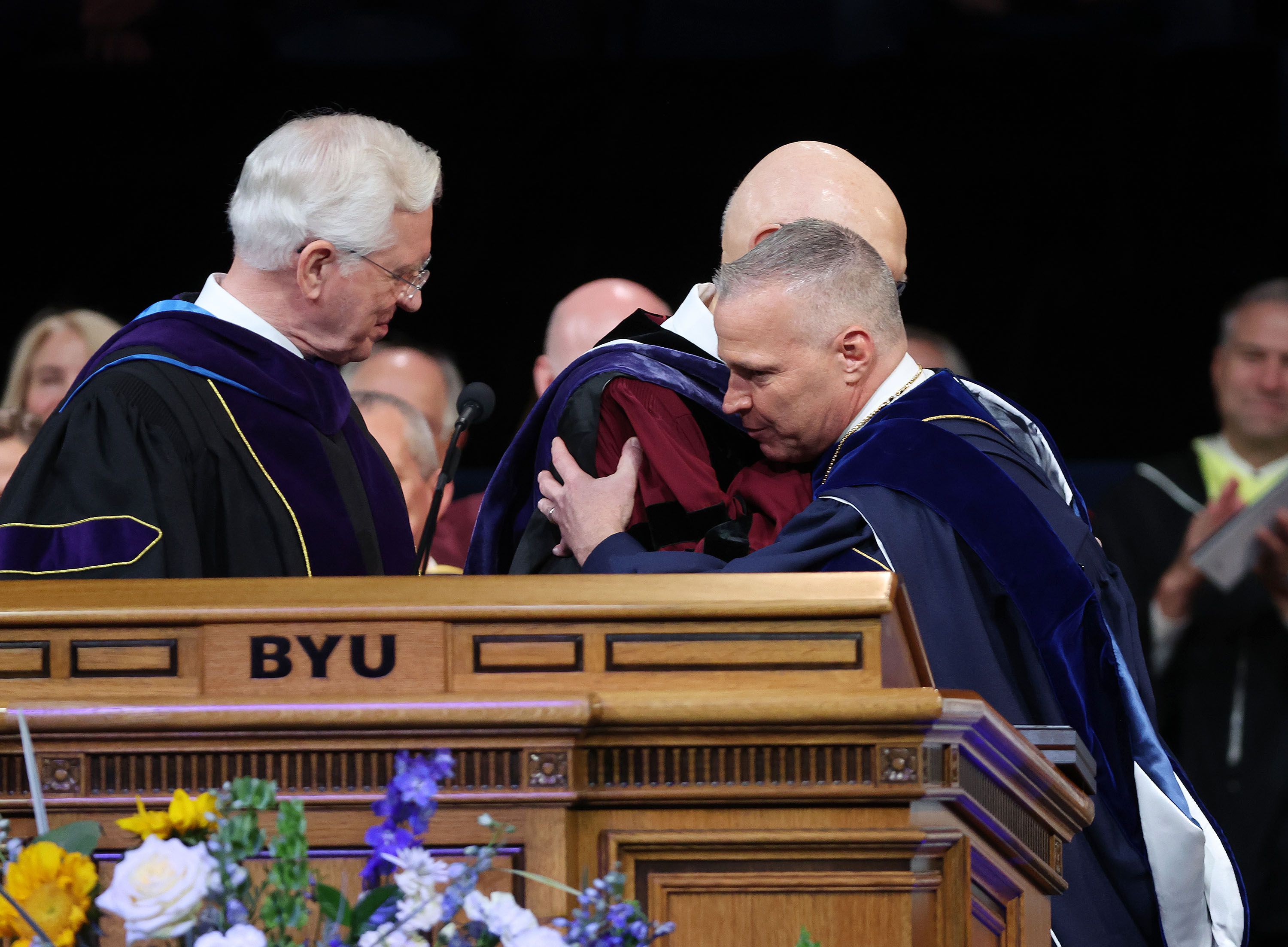 BYU President C. Shane Reese hugs President Dallin H. Oaks, first counselor in the First Presidency of The Church of Jesus Christ of Latter-day Saints, during his installation as BYU’s 14th president at the Marriott Center in Provo on Tuesday. Elder D. Todd Christofferson of the Quorum or the Twelve Apostles, left, looks on.