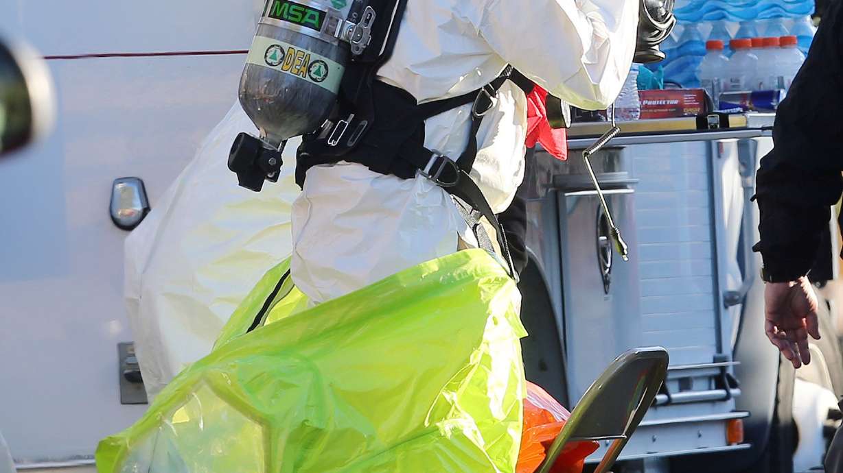 Police and agents with the Drug Enforcement Administration put on protective gear as local and federal law enforcement agencies respond to a drug bust in Cottonwood Heights on Nov. 22, 2016. DEA agents discovered at least several hundred thousand illicit fentanyl pills at a home in what they called an “absolutely catastrophic” undercover drug dealing operation.