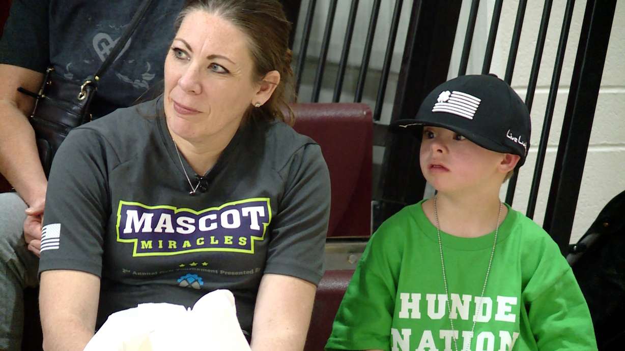 Nine-year-old Finn Merkley and his mother Amber Merkley wait for Finn’s turn in the ring with a pesky mascot.