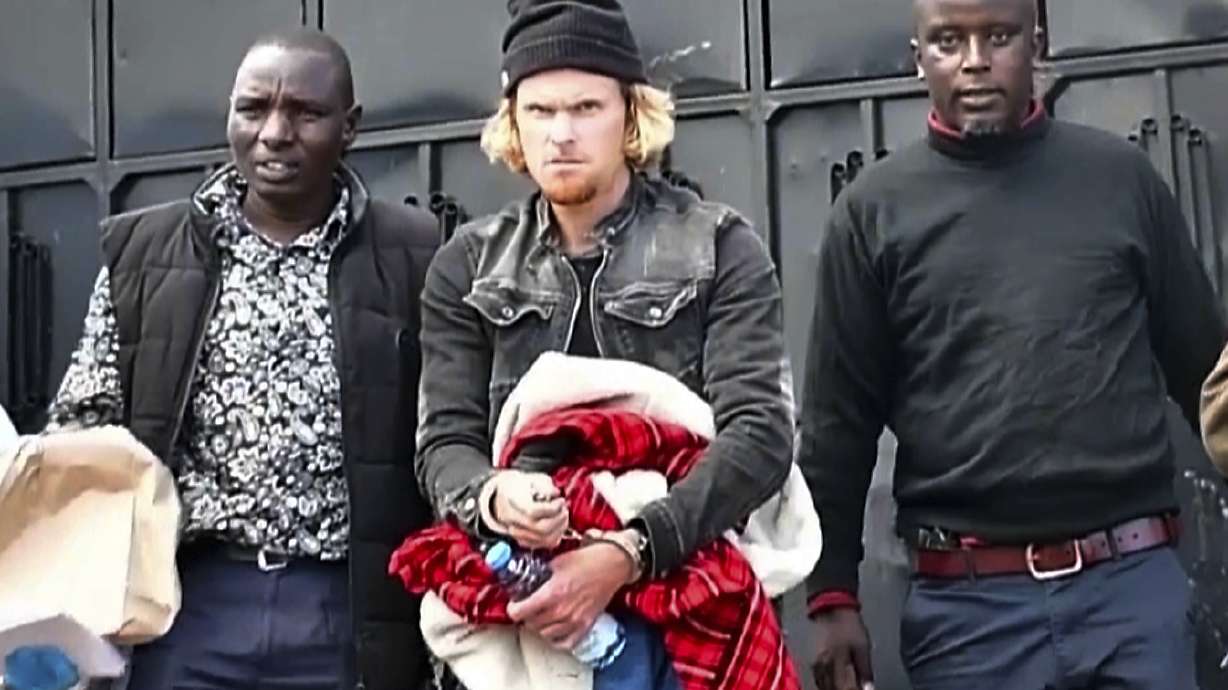 In this picture taken from video New Zealand's Olympic runner Zane Robertson, center, is arrested at his home in Iten, Kenya, Wednesday, Sept. 20, 2023. Police obtained a court order to hold Robertson in custody for five working days while they question him and investigate. He appeared in court on Thursday for a short hearing and police said that he would be charged after the investigations are completed.
