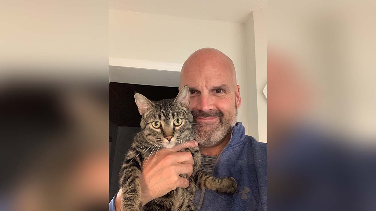 Scott Donnachie and his cat George, who is missing. St. George police are warning of scams targeting pet owners who are looking for missing animal.