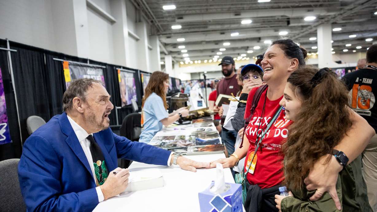 Actor John Rhys-Davies, known for playing Gimli in "The Lord of the Rings" trilogy, jokes around while signing an autograph for Caterina Mazzari and her daughters at the FanX convention at the Salt Palace in Salt Lake City on Thursday.