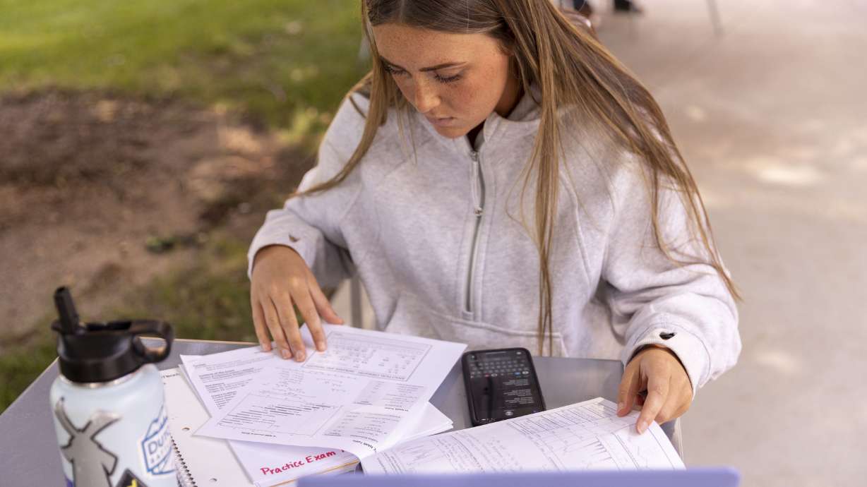 Sidne Boadwine, a junior at Boise State University, does classwork in Boise on Sept. 22, 2022. Sens. Mitt Romney, R-Utah, and Kyrsten Sinema, I-Ariz., reintroduced a bill Thursday to address student loan debt and make colleges more affordable.