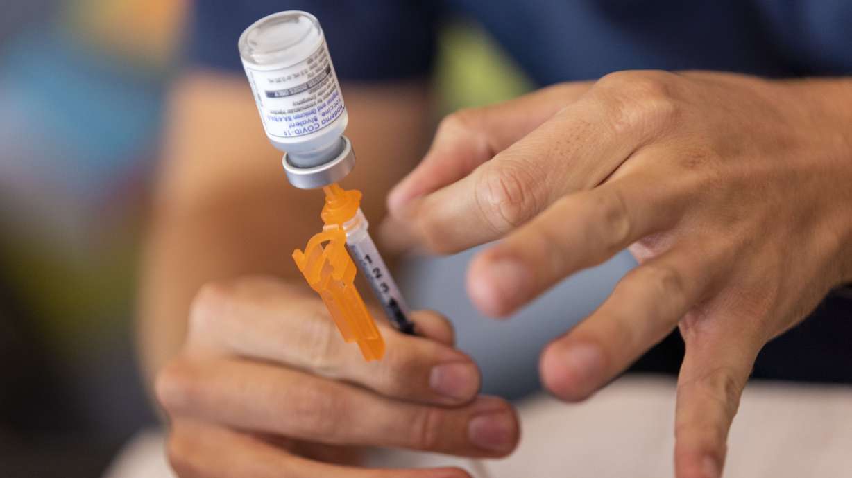 Nurse Aydan Elzinga prepares a COVID-19 booster shot at the Kearns Library in Kearns on Sept. 29, 2022. Patients seeking the updated vaccine are being told to "check back" later this month, running into insurance issues.