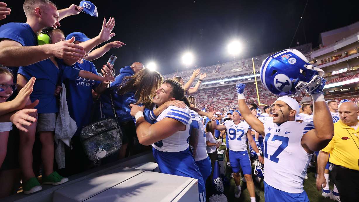 Brigham Young tight end Isaac Rex (83) and long snapper Dalton Riggs (47) celebrate the win over the Arkansas Razorbacks at Razorback Stadium in Fayetteville on Saturday, Sept. 16, 2023. BYU won 38-31.