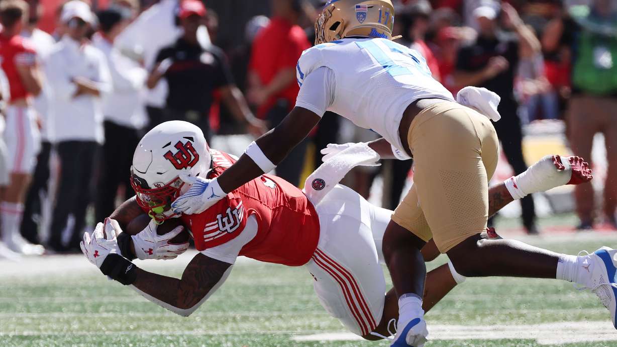 Utah Utes running back Ja'Quinden Jackson (3) dives for additional yardage against UCLA Bruins linebacker Jalen Woods (17) in Salt Lake City on Saturday, Sept. 23, 2023.