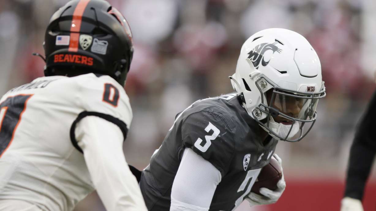 Washington State wide receiver Josh Kelly (3) carries the ball while pressured by Oregon State defensive back Akili Arnold (0) during the first half of an NCAA college football game, Saturday, Sept. 23, 2023, in Pullman, Wash.