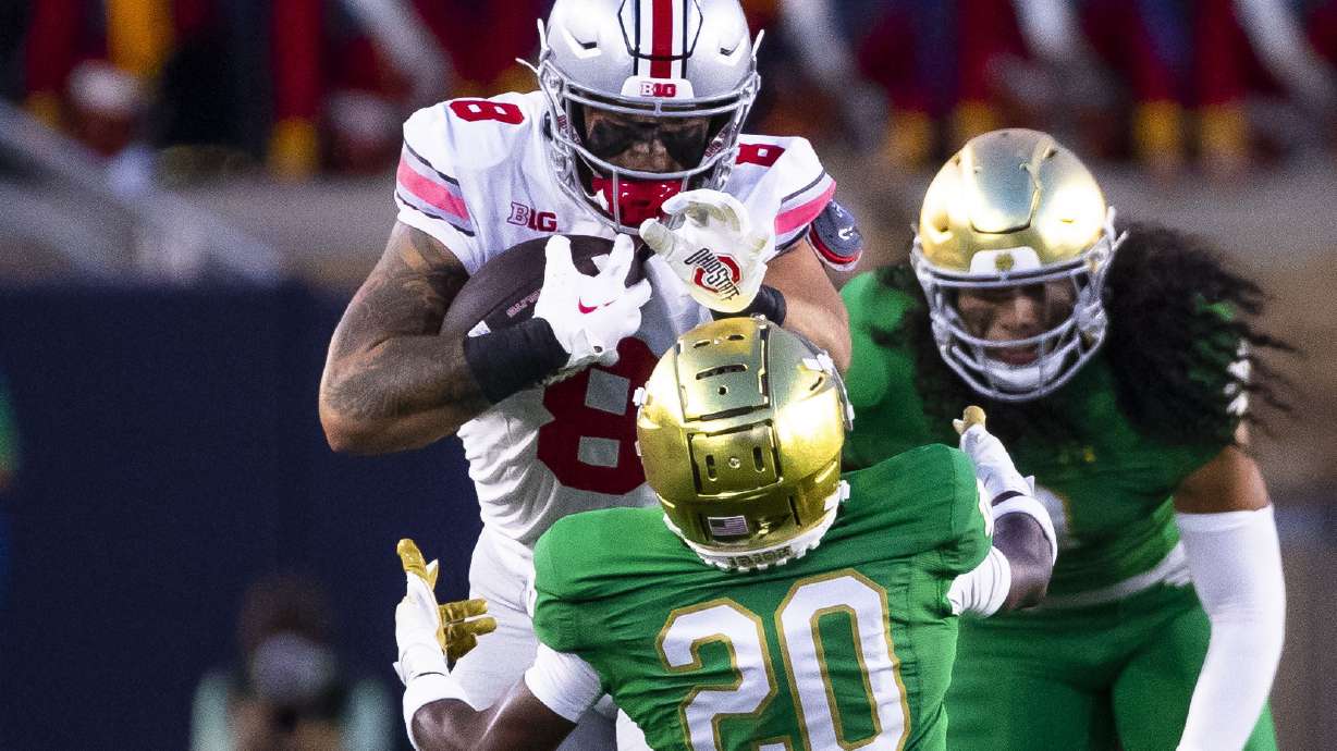 Ohio State's Cade Stover (8) pushes Notre Dame's Benjamin Morrison (20) over during the first half of an NCAA college football game Saturday, Sept. 23, 2023, in South Bend, Ind.
