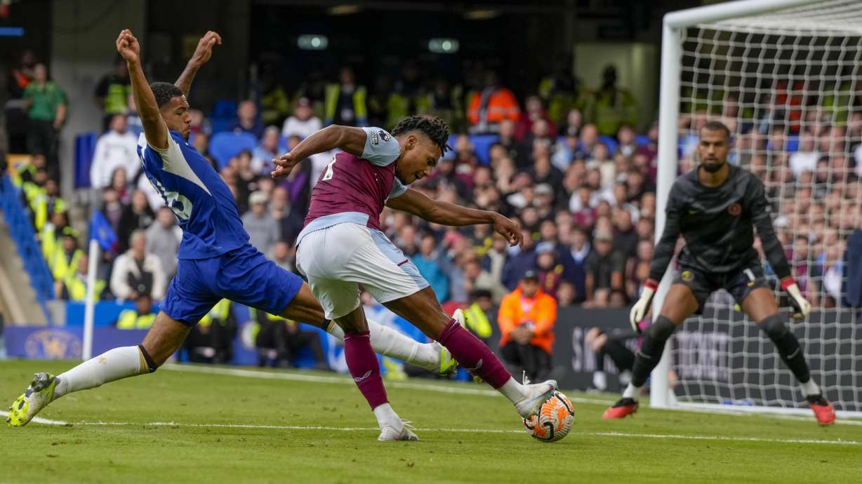 Aston Villa's Ollie Watkins, center, scores his side's opening goal during the English Premier League soccer match between Chelsea and Aston Villa at Stamford Bridge stadium in London, Sunday, Sept. 24, 2023.