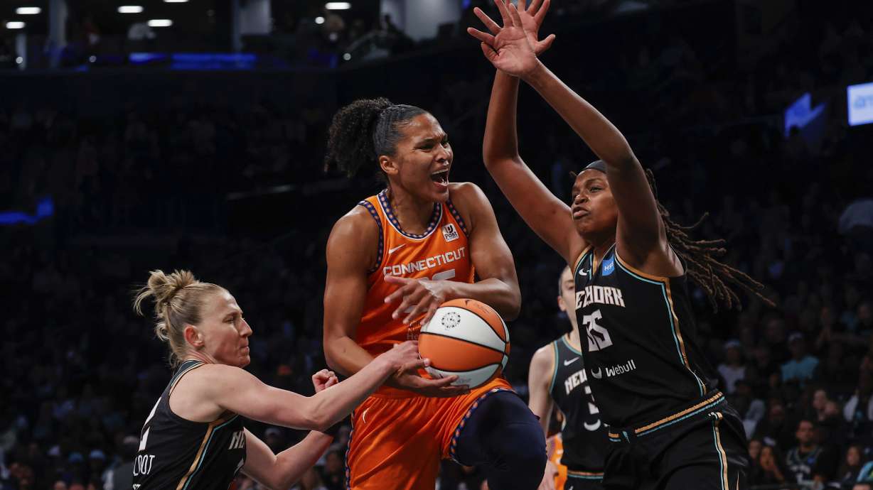 Connecticut Sun forward Alyssa Thomas, center, drives to basket against New York Liberty forward Jonquel Jones, right and guard Courtney Vandersloot during the first quarter of a WNBA basketball game Sunday, Sept. 24, 2023, in New York