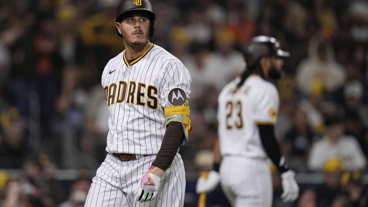 San Diego Padres' Manny Machado, left, passes teammate Fernando Tatis Jr. after striking out during the fourth inning of a baseball game against the San Francisco Giants, Thursday, Aug. 31, 2023, in San Diego.