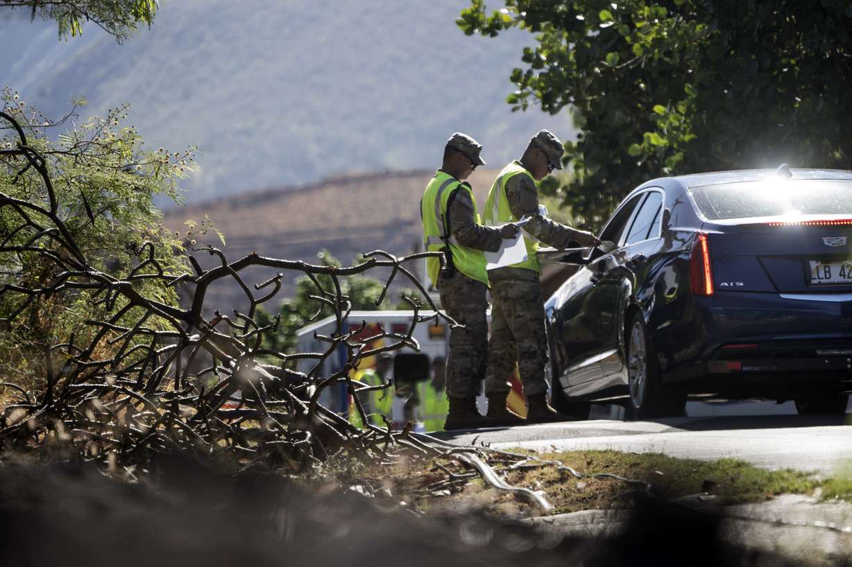 Members of the Hawaii National Guard check on a car passing the checkpoint on Kaniau Road, Monday, in Lahaina, Hawaii. A small group of Lahaina residents returned to their devastated properties Monday for the first time since the Hawaii town was destroyed by wildfire nearly seven weeks earlier.