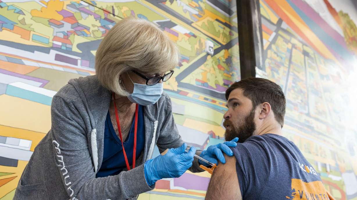 Nurse Cathy Martin administers a COVID-19 booster shot to Bryce Park at the Kearns Library in Kearns on Sept. 29, 2022. Thousands of claims are being denied daily despite "legal obligations," the U.S. Health and Human Services secretary says.