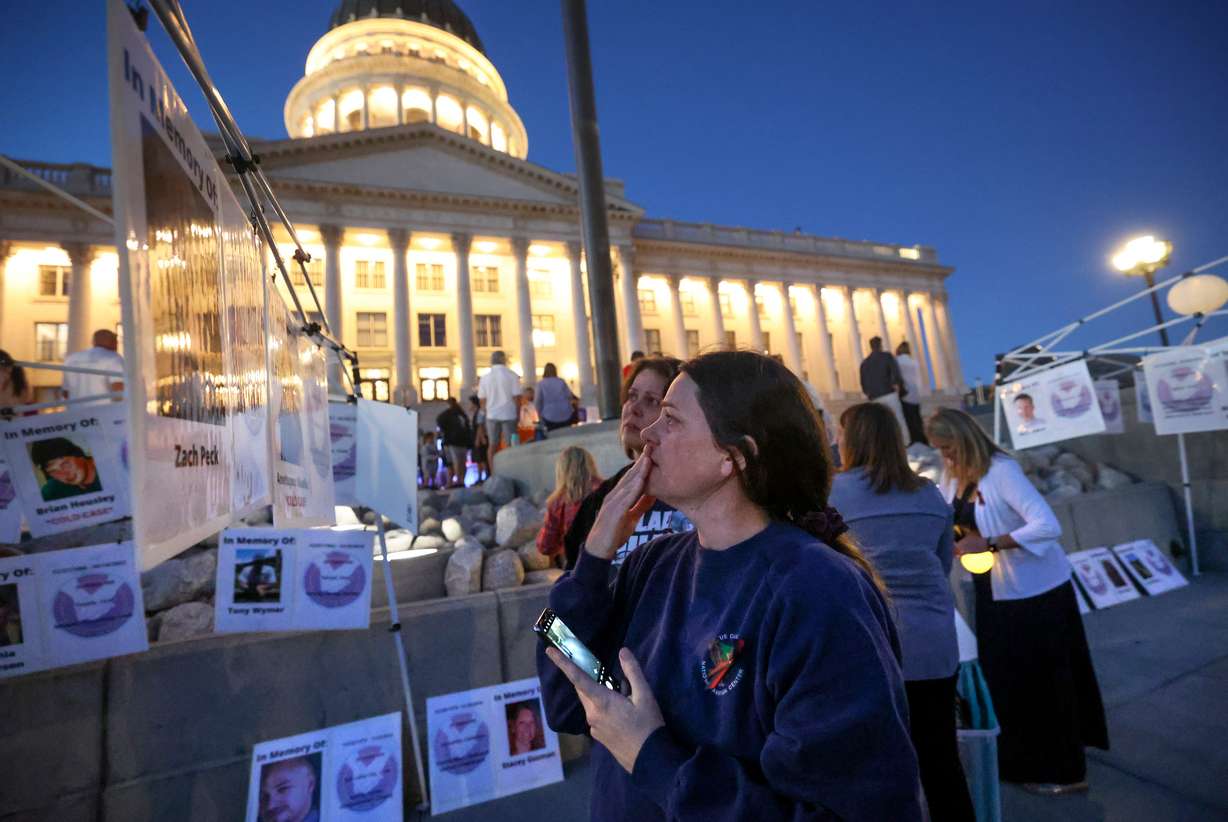 Sommer Funai, front, and Autumn Wagner read about a homicide victim during Utah's National Day of Remembrance for Homicide Victims event outside of the Capitol in Salt Lake City on Monday. Funai and Wagner lost their sister Heidi Wagner, who was murdered by her husband.