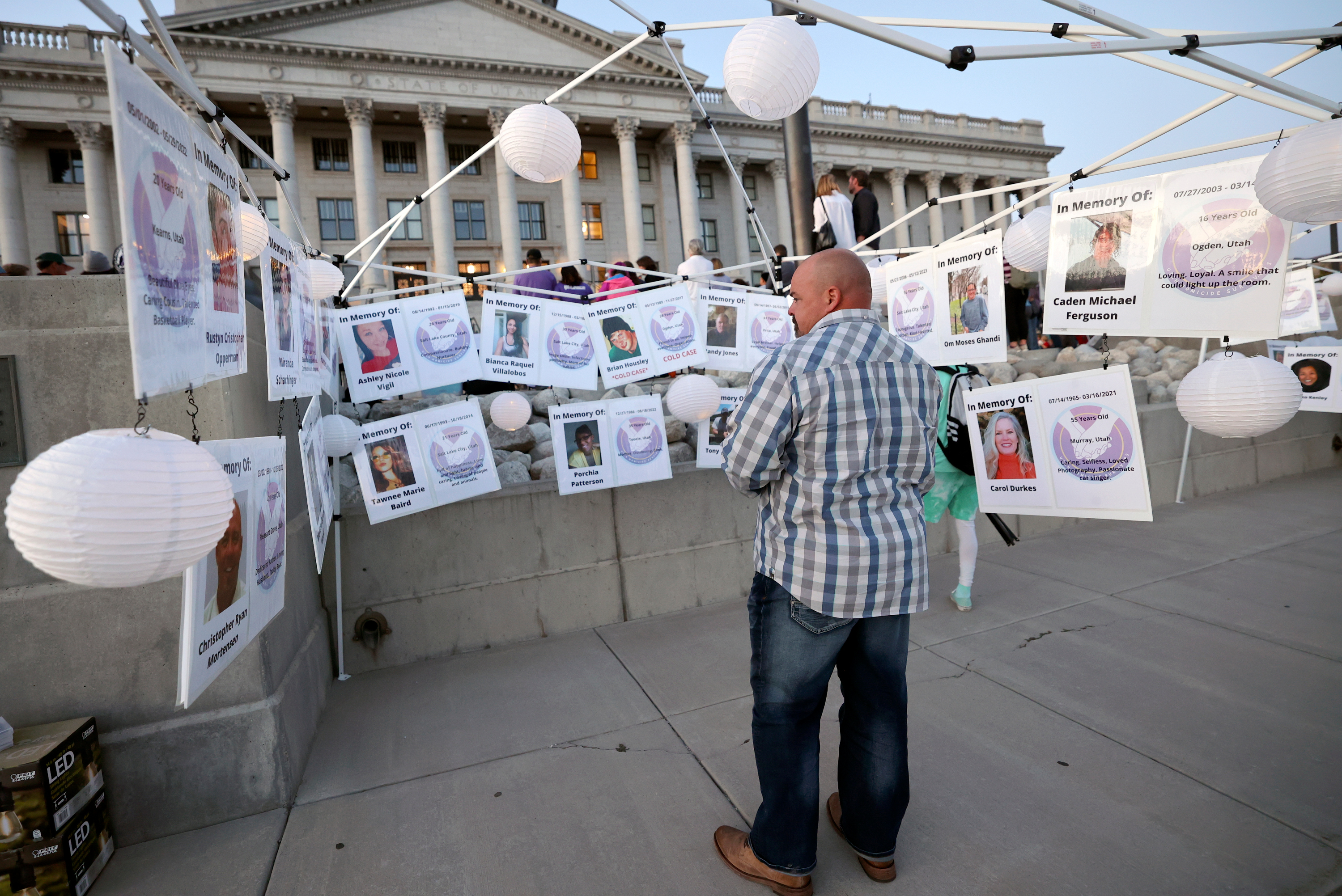 Matt Draper looks at photos of homicide victims during Utah's National Day of Remembrance for Homicide Victims event outside of the Capitol in Salt Lake City on Monday. Draper said his stepson was murdered by his stepson’s father in a murder-suicide.