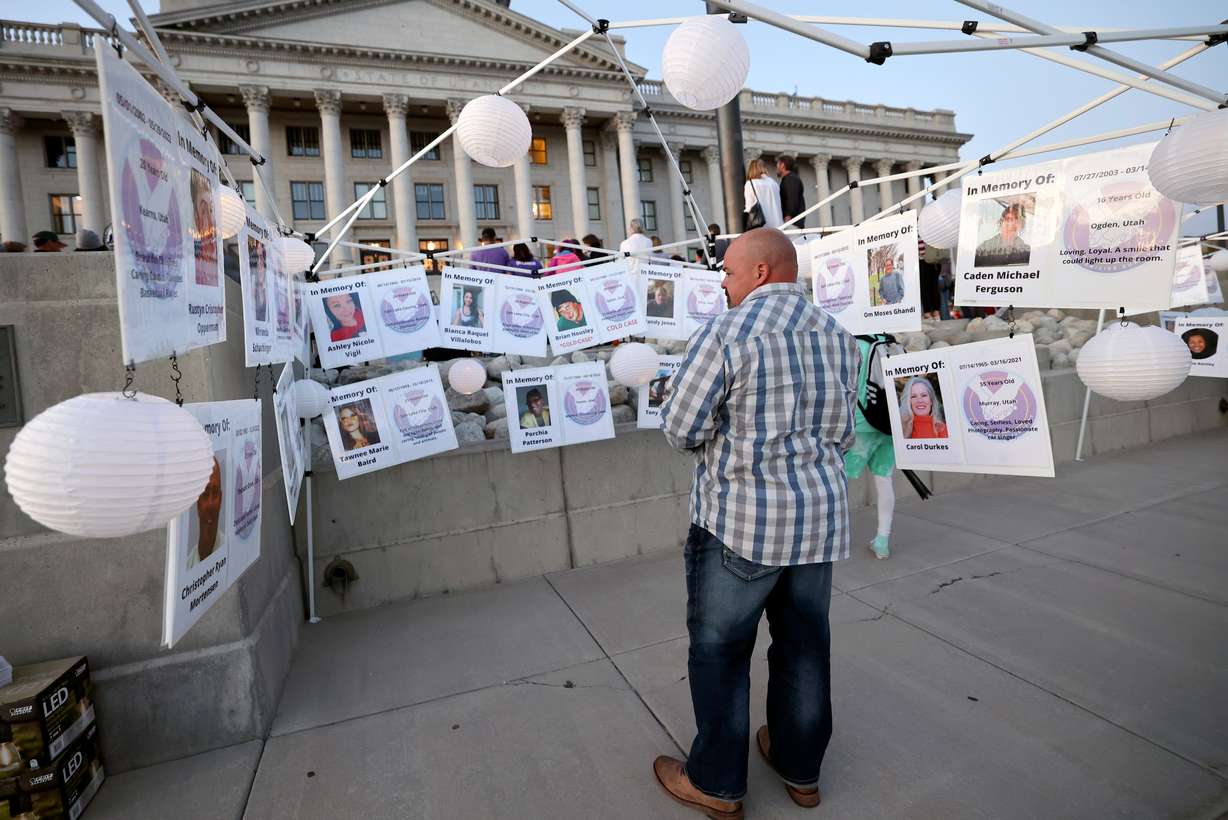 Matt Draper looks at photos of homicide victims during Utah's National Day of Remembrance for Homicide Victims event outside of the Capitol in Salt Lake City on Monday. Draper said his stepson was murdered by his stepson’s father in a murder-suicide.