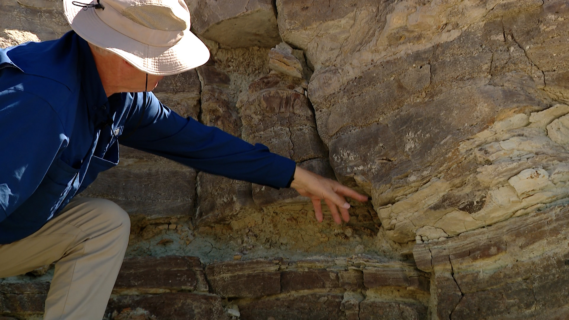 Brookes Britt points out some dinosaur tracks left in the rocks at Utahraptor State Park north of Moab on Monday.
