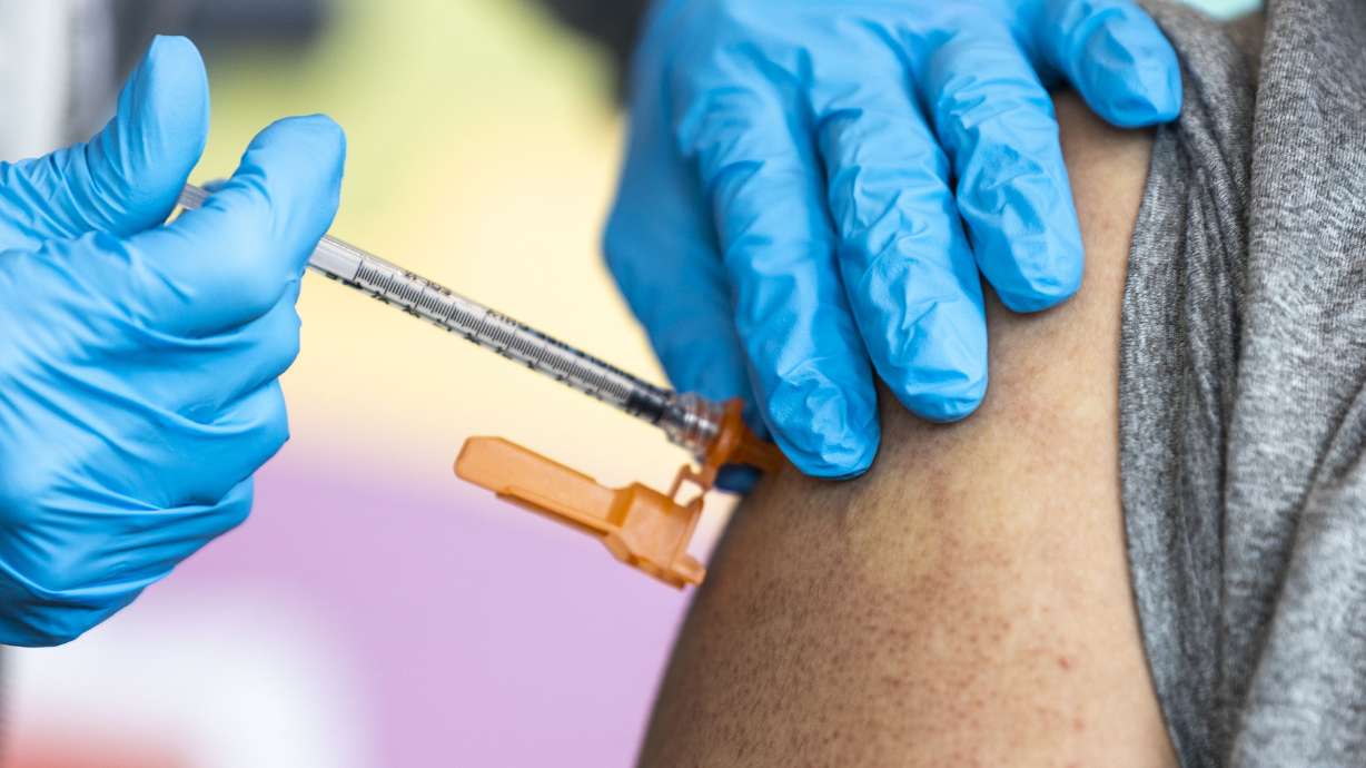 Nurse Cathy Martin administers a COVID-19 booster shot to Sergio Ruiz at the Kearns Library in Kearns on Sept. 29, 2022.
