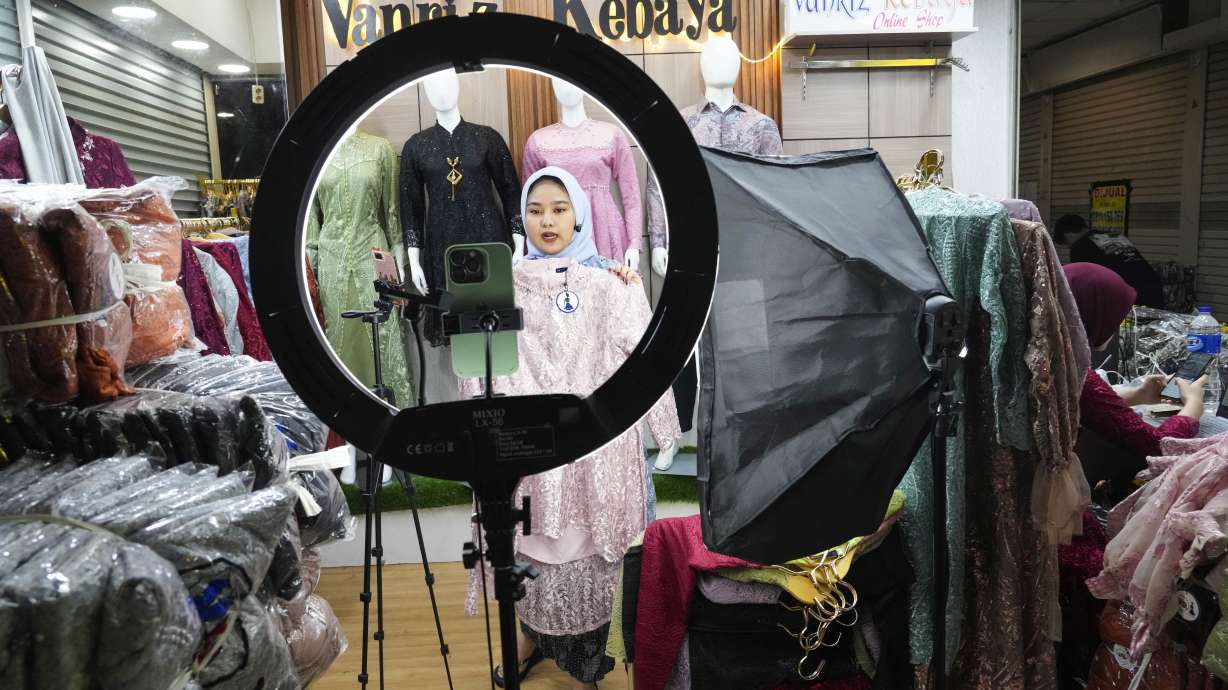 A trader conducts live sales via streaming at a store in the Tanah Abang textile market in Jakarta, Indonesia Thursday, Sept. 28, 2023. Chinese-owned app TikTok on Thursday said it regretted the Indonesian government's decision to ban e-commerce transactions on social media platforms, particularly the impact it would have on the millions of sellers who use TikTok Shop.