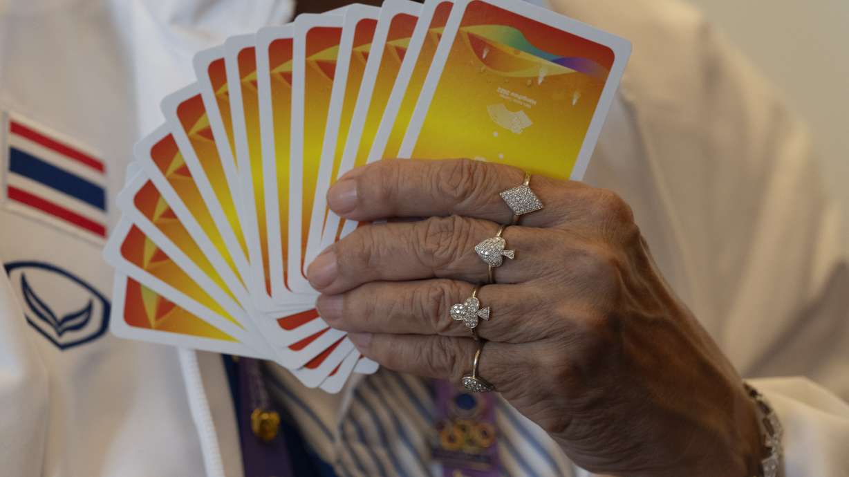 Manthanee Yaisawang from Thailand wears jewelry with the Diamond, Spade, Club and Heart symbol of playing cards as she takes part in the Bridge Women's Team Round Robin event against India for the 19th Asian Games in Hangzhou, China, Wednesday, Sept. 27, 2023. The 500-year-old card game of bridge is another type of "esport" at the Asian Games. With an apology to the demographic, here the "e" stands for elderly, not electronic, as in the youth-driven, video-game competition that's soaring in popularity, generating billions in revenue, and producing superstars like the South Korean gamer known as Faker.