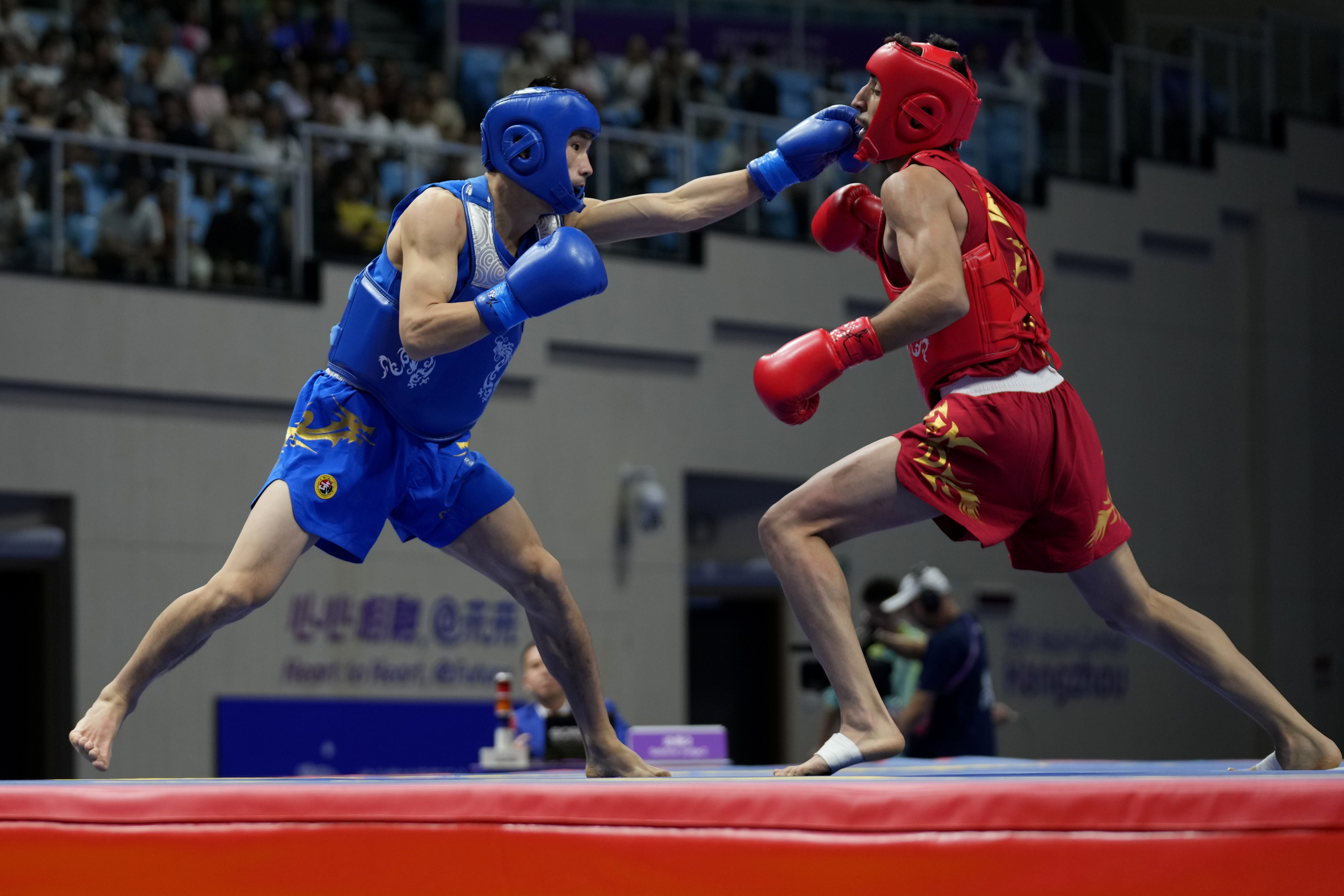 China's Xuetao Wang, left, fights Iran's Shoja Panahigelehkolaei in the Wushu men's 60kg final at 19th Asian Games in Hangzhou, China, Thursday, Sept. 2, 2023.
