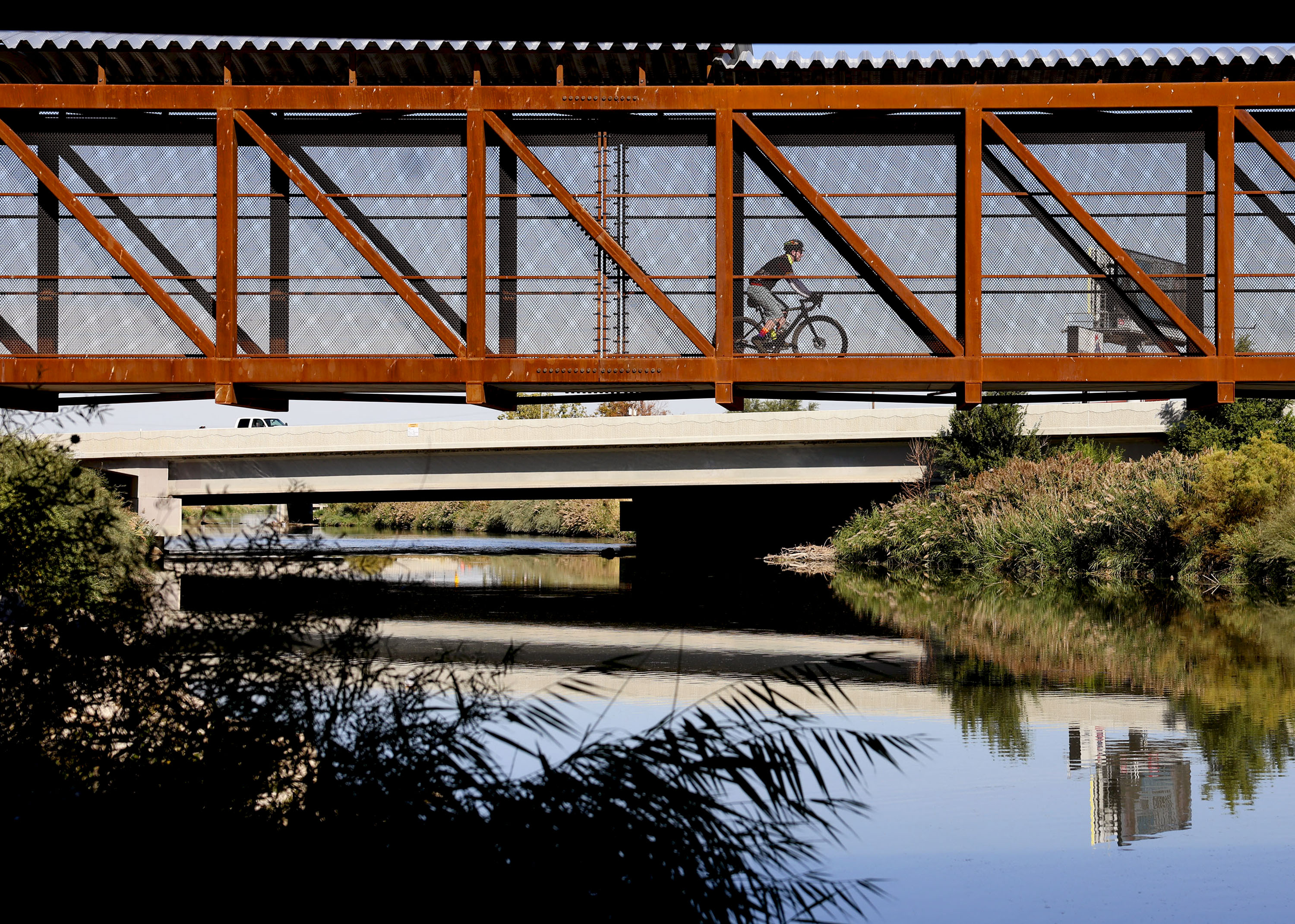 A cyclist pedals across a bridge over the Jordan River section of Parleys Trail in West Valley City on Thursday. Comprised of two elevated bridges, across 900 West and over the Jordan River, the new section is referred to as “Bridging the Gap: Connecting Communities.”