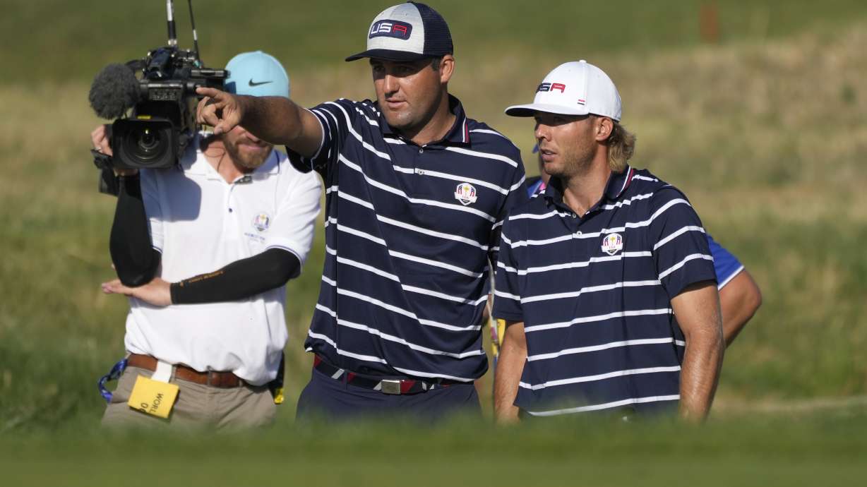United States' Scottie Scheffler, left gestures with playing partner United States' Sam Burns during their morning Foursome match on the 11th green at the Ryder Cup golf tournament at the Marco Simone Golf Club in Guidonia Montecelio, Italy, Friday, Sept. 29, 2023.