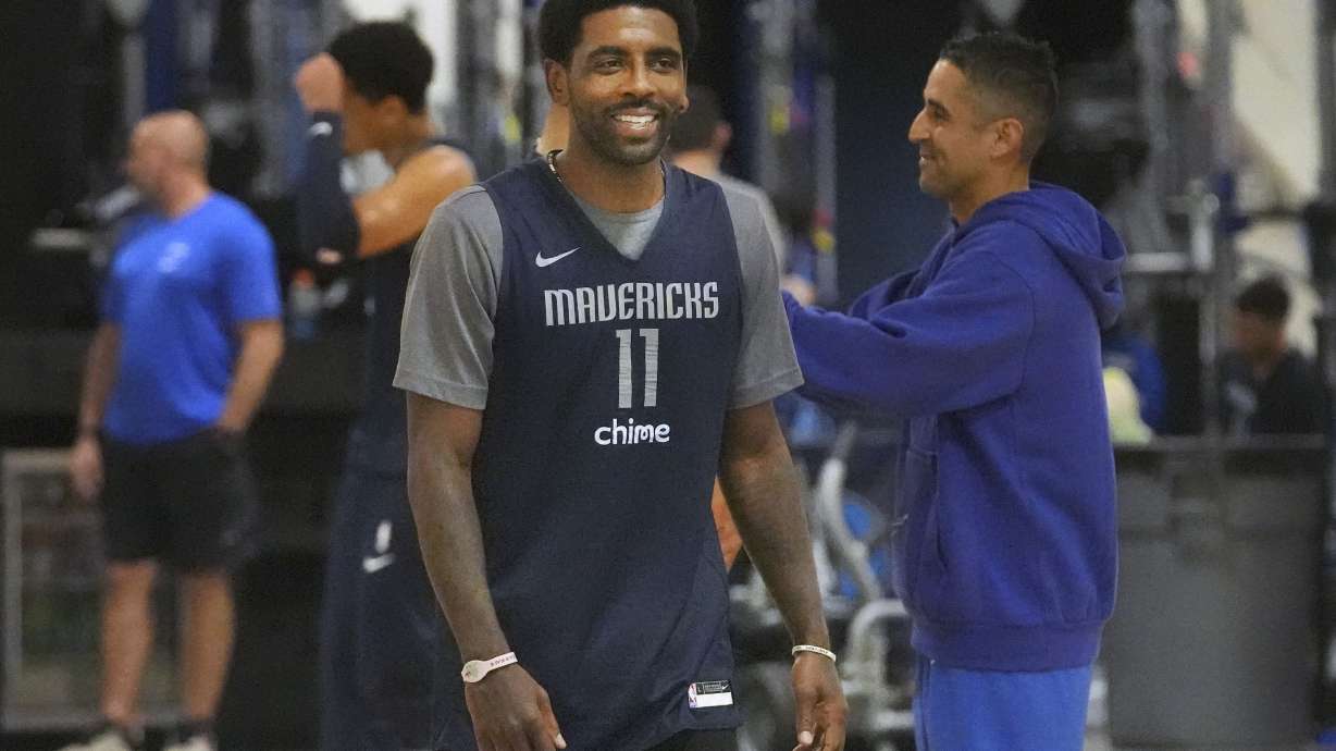 Dallas Mavericks guard Kyrie Irving smiles as he walks on the court during an NBA basketball training camp in Dallas, Thursday, Sept. 28, 2023.