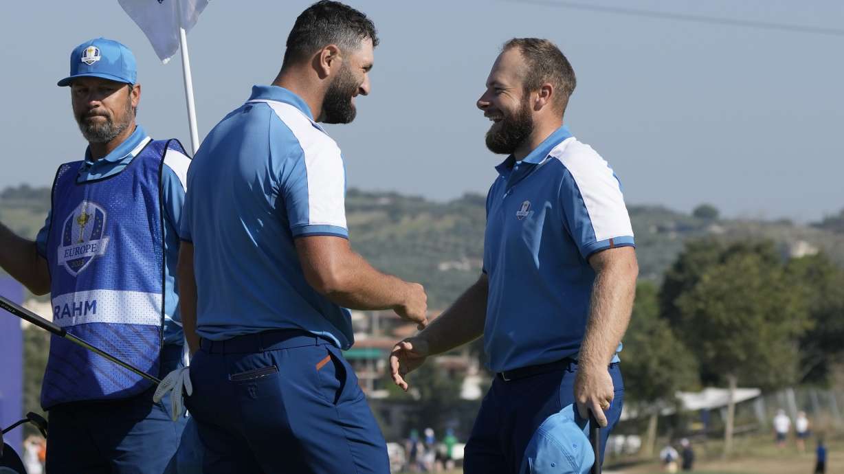Europe's Jon Rahm, left and playing partner Europe's Tyrrell Hatton celebrate on the 15th green after winning their morning Foursome match 4&3 at the Ryder Cup golf tournament at the Marco Simone Golf Club in Guidonia Montecelio, Italy, Friday, Sept. 29, 2023.