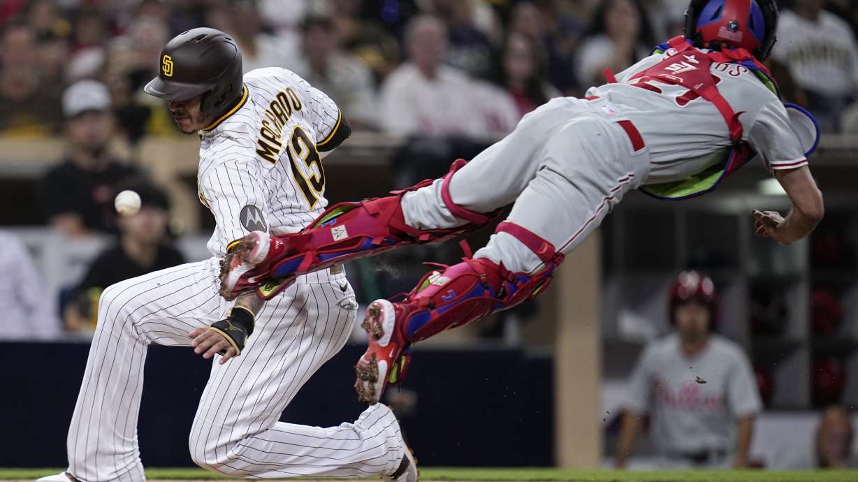 FILE - San Diego Padres' Manny Machado, left, scores from third base off a fielder's choice by Luis Campusano as Philadelphia Phillies catcher Garrett Stubbs can't reach the throw during the fourth inning of a baseball game Tuesday, Sept. 5, 2023, in San Diego. San Diego Padres' Xander Bogaerts scored and Philadelphia Phillies second baseman Bryson Stott picked up a throwing error on the play. Errors are becoming increasingly rare in the major leagues. There were just 2,459 errors entering the final weekend of the regular season, on track to finish the fewest in a non-shortened year since 1960 _ when there were just 16 teams.