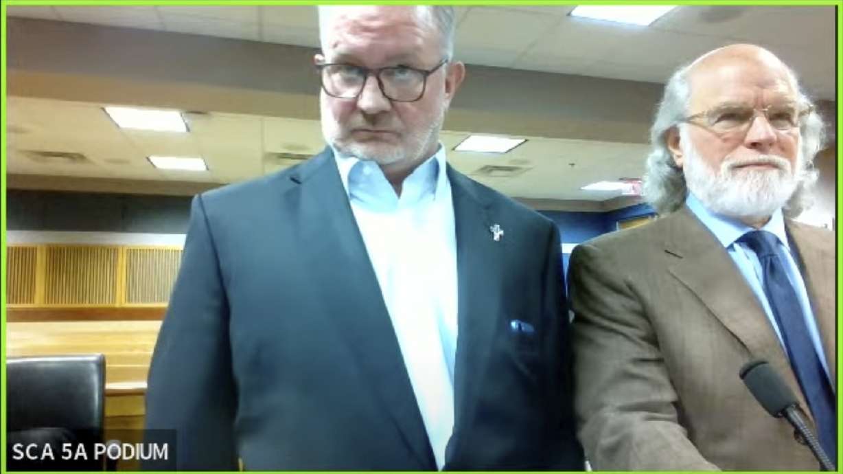 In this image made from video from Judge Scott McAfee's virtual Zoom hearing, Scott Graham Hall, left, stands with his attorney Jeff Weiner, right, in Superior Court of Fulton County before Judge McAfee, not pictured, in Courtroom 5A on Friday in Atlanta. Hall, a bail bondsman charged alongside former President Donald Trump and 17 others in the Georgia election interference case, pleaded guilty to misdemeanor charges.