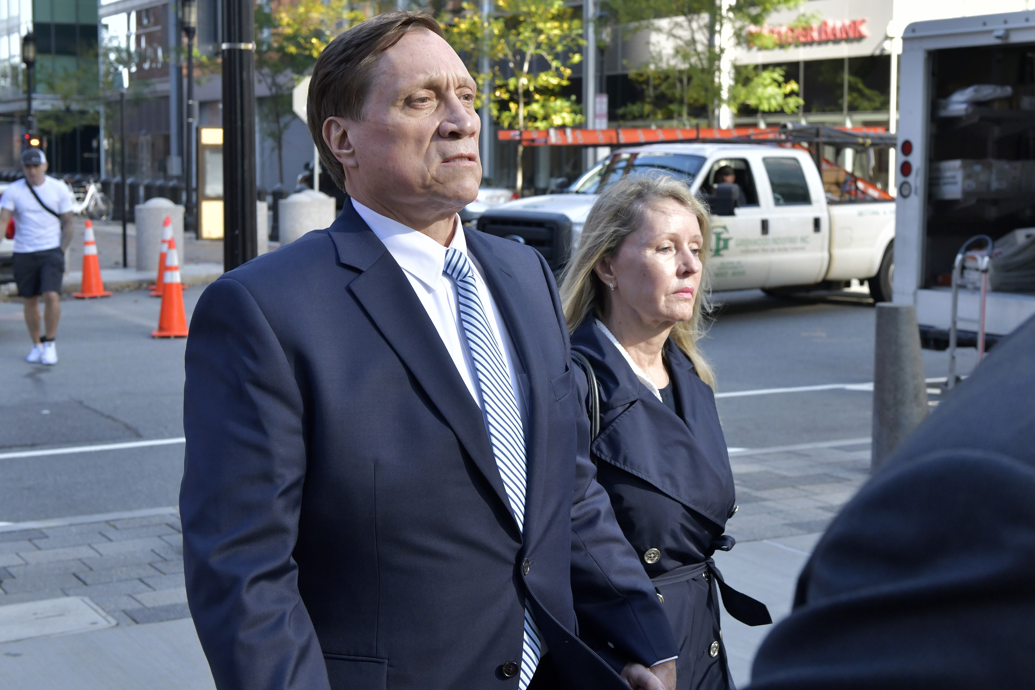 FILE - John Wilson, left, and his wife leave federal court after he was found guilty of participating in a fraudulent college admissions scheme, Oct. 8, 2021, in Boston. The former Staples Inc. executive Wilson, whose fraud and bribery convictions in the sprawling college admissions cheating scandal were thrown out by an appeals court, was sentenced on Friday, Sept. 29, 2023, to six months of home confinement for a tax offense. 