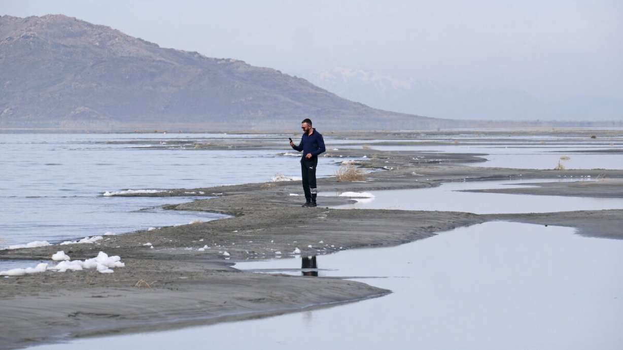 Ruben Gyoeltsyan walks across a sand bar at the receding edge of the Great Salt Lake on March 3, 2022, near Salt Lake City. Utah lawmakers passed a $40 million proposal through the state Senate that would pay water rights holders to conserve and fund habitat restoration to prevent the lake from shrinking further.