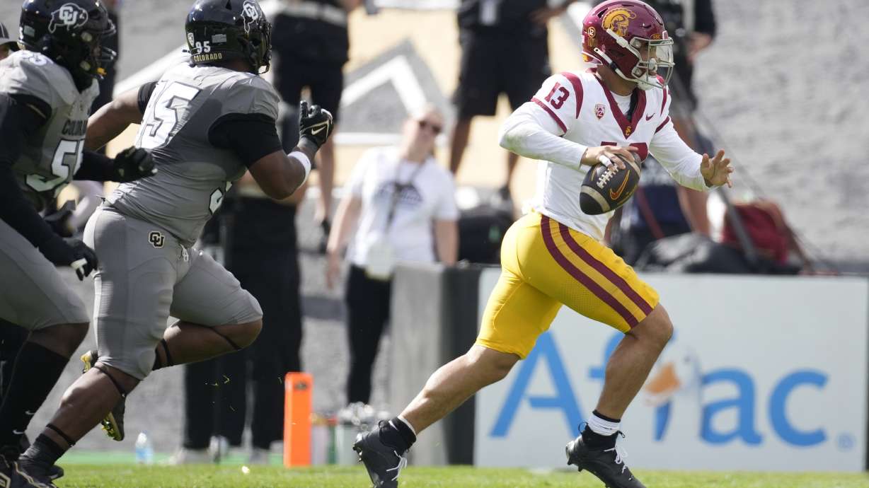 Southern California quarterback Caleb Williams, right, looks to pass the ball as Colorado defensive lineman Bishop Thomas pursues in the first half of an NCAA college football game, Saturday, Sept. 30, 2023, in Boulder, Colo.