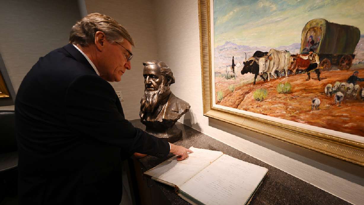 Zions Bank President CEO Scott Anderson shows signatures of Brigham Young and other leaders of The Church of Jesus Christ of Latter-day Saints in a bank ledger that is at the corporate offices in Salt Lake City on Sept. 20.