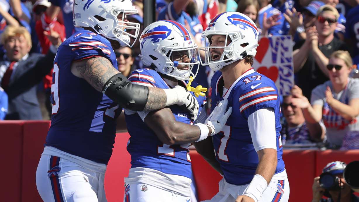 Buffalo Bills wide receiver Stefon Diggs, center, celebrates his touchdown with offensive tackle Spencer Brown, left, and quarterback Josh Allen, right, during the first half an NFL football game against the Miami Dolphins, Sunday, Oct. 1, 2023, in Orchard Park, N.Y.