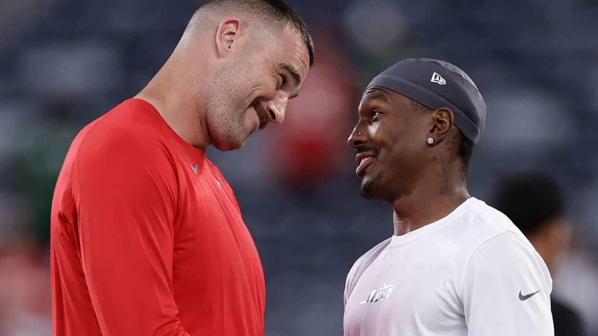 Kansas City Chiefs tight end Travis Kelce, left, talks with New York Jets wide receiver Mecole Hardman Jr. before playing in an NFL football game, Sunday, Oct. 1, 2023, in East Rutherford, N.J.