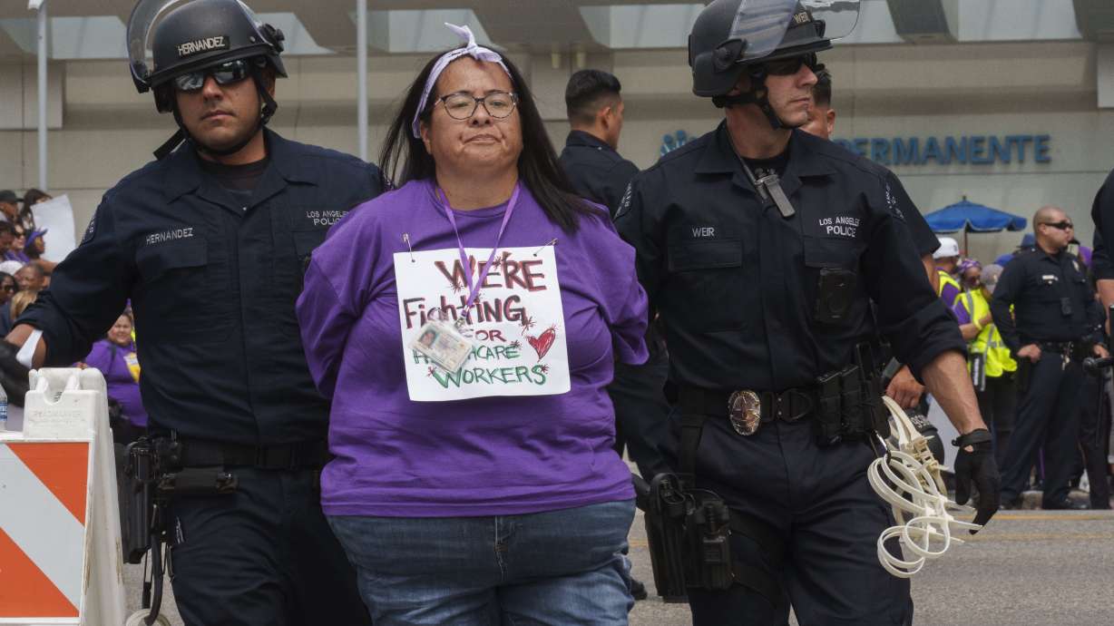A health care worker risks arrest outside Kaiser Permanente Los Angeles Medical Center in Los Angeles Sept. 4. Workers are planning a three-day strike starting Wednesday if they can’t reach an agreement.