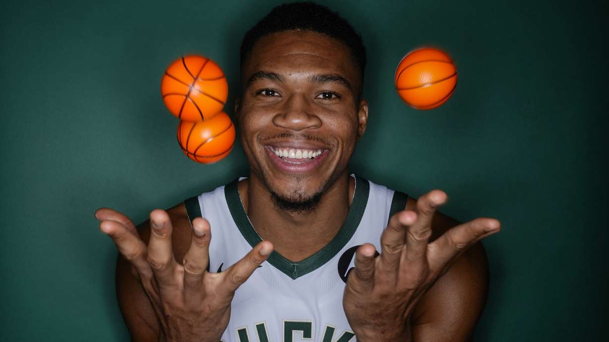 Milwaukee Bucks' Giannis Antetokounmpo tosses some ball as he poses for a picture during the NBA basketball team's media day in Milwaukee Monday, Oct. 2, 2023.