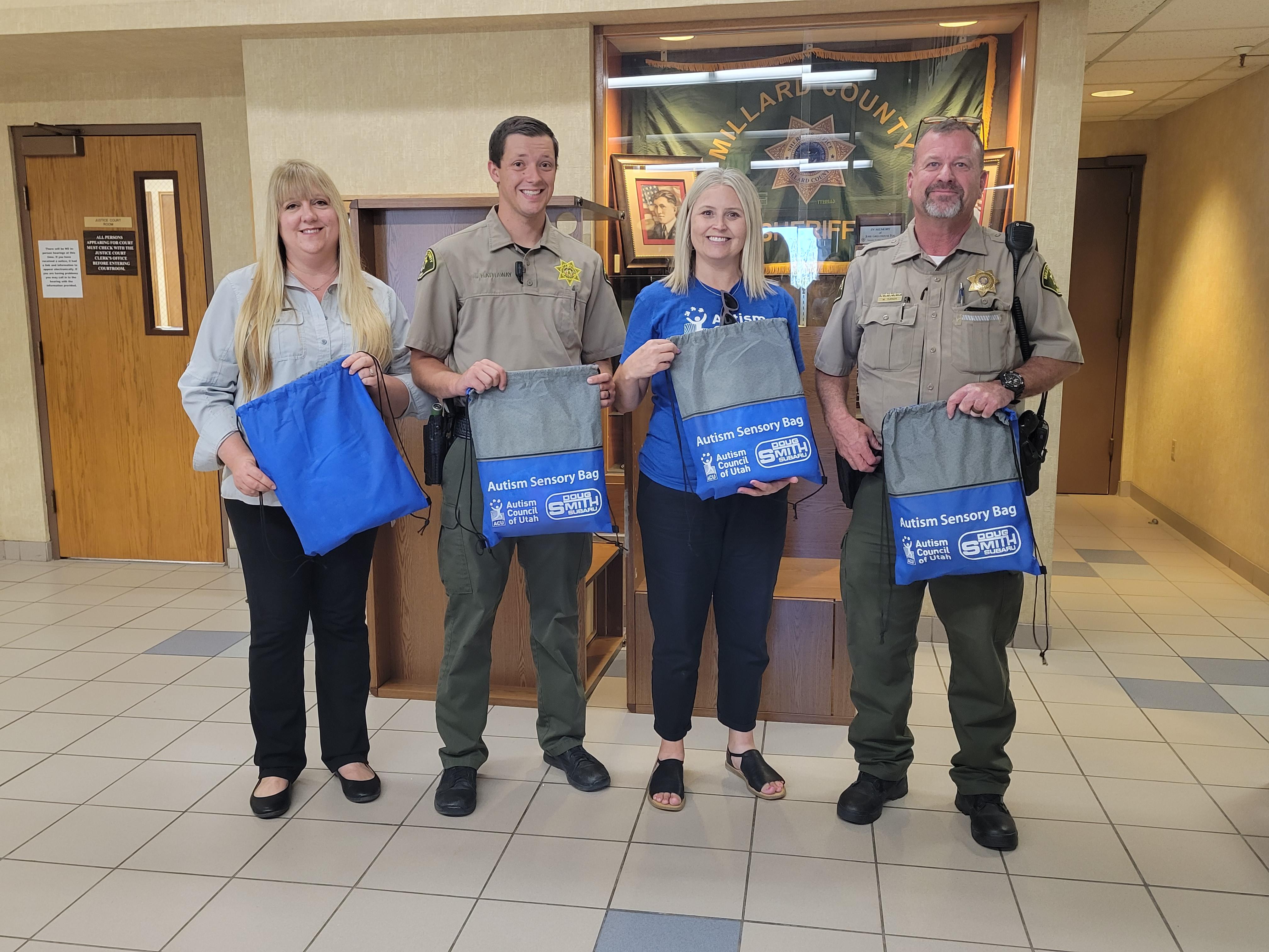 Michelle Hiles, center right, stands with employees at the Millard County Sheriff’s Office after they received autism sensory bags for deputies.