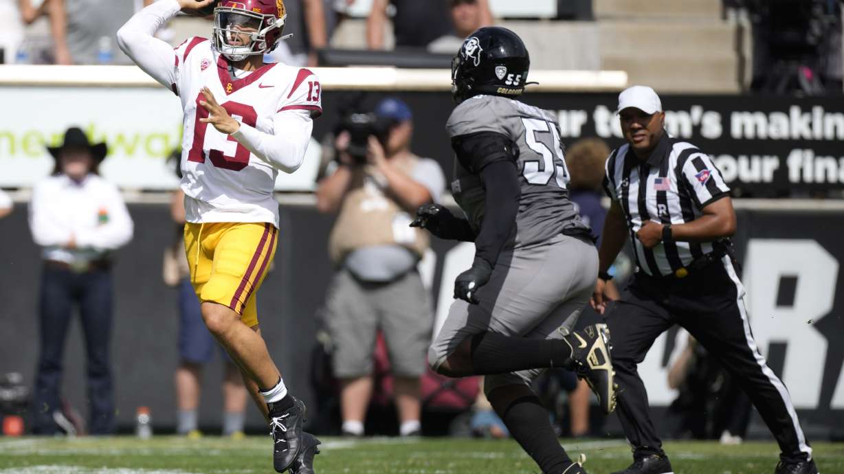 Southern California quarterback Caleb Williams, left, throws a pass under pressure from Colorado defensive lineman Leonard Payne Jr. in the second half of an NCAA college football game, Saturday, Sept. 30, 2023, in Boulder, Colo.