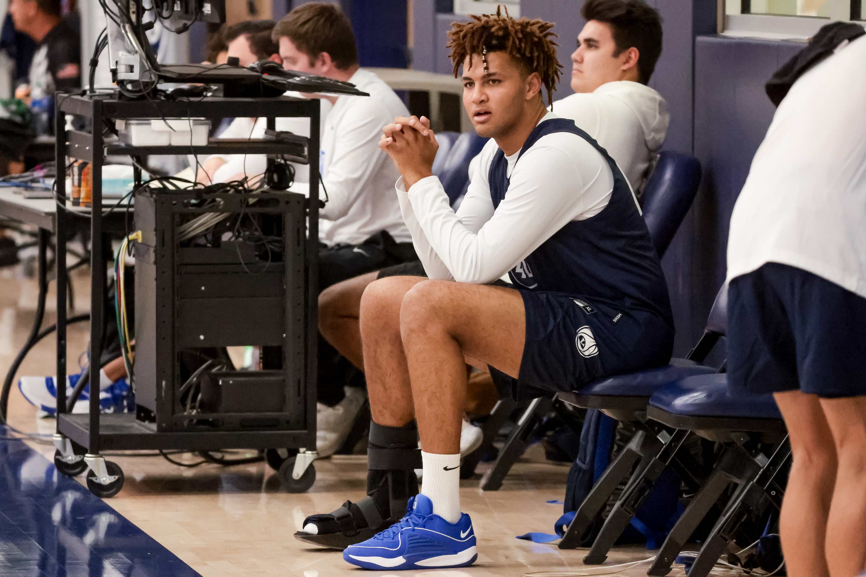 Marcus Adams Jr. sits on the sideline wearing a boot on his foot during BYU basketball practice at the Marriott Center Annex Court in Provo on Tuesday, Oct. 3, 2023.