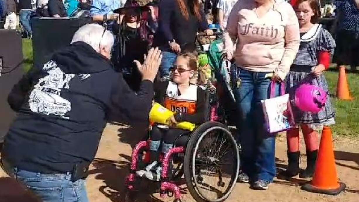 Mark Kristensen, co-founder and president of Angel's Hands Foundation gives out high-fives during the kids costume parade at last year's car show.