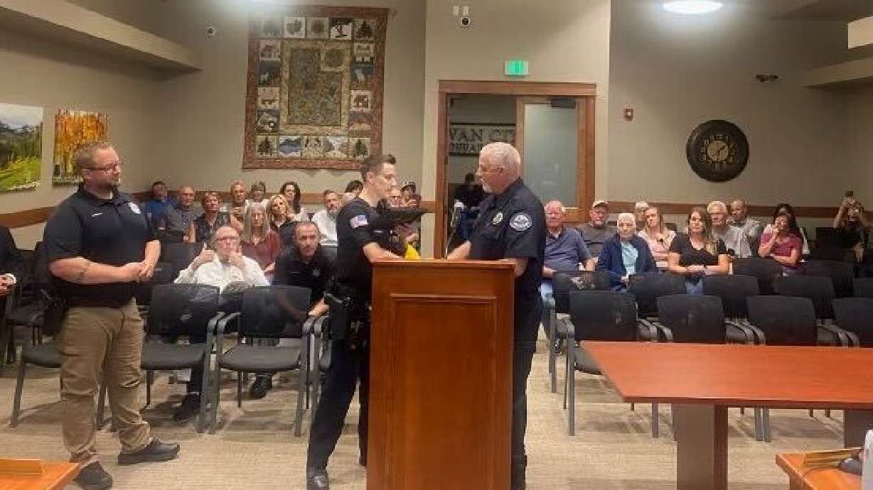 Parowan Police Chief Addison Adams presents officer Thomas Hart with a lifesaving award certificate during a Parowan City Council meeting, Parowan, Sept. 14.