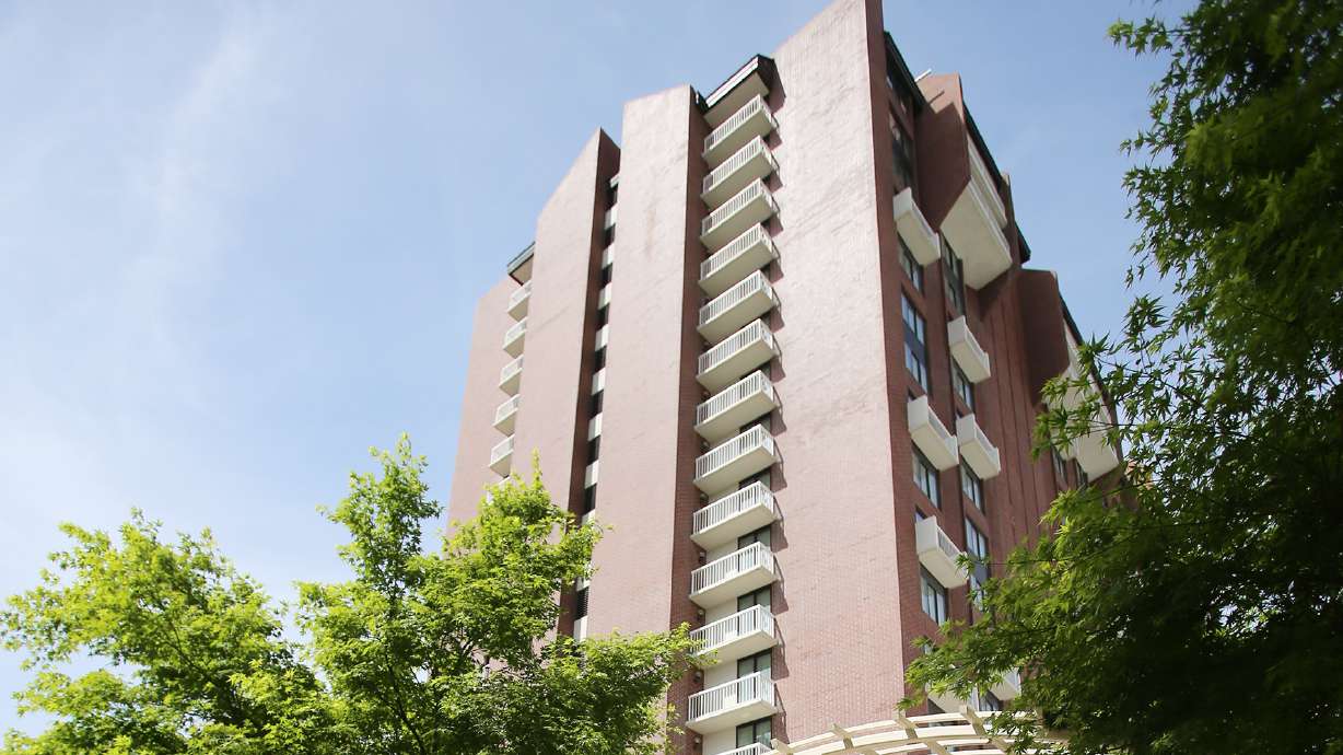 A man was charged Tuesday with throwing furniture from the 14th floor of the Little America hotel in Salt Lake City into a pool below, and trying to grab an officer's gun, police said.