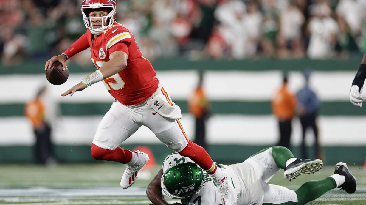 Kansas City Chiefs quarterback Patrick Mahomes (15) is tripped up by New York Jets linebacker Bryce Huff (47) as he throws during the second quarter of an NFL football game, Sunday, Oct. 1, 2023, in East Rutherford, N.J.