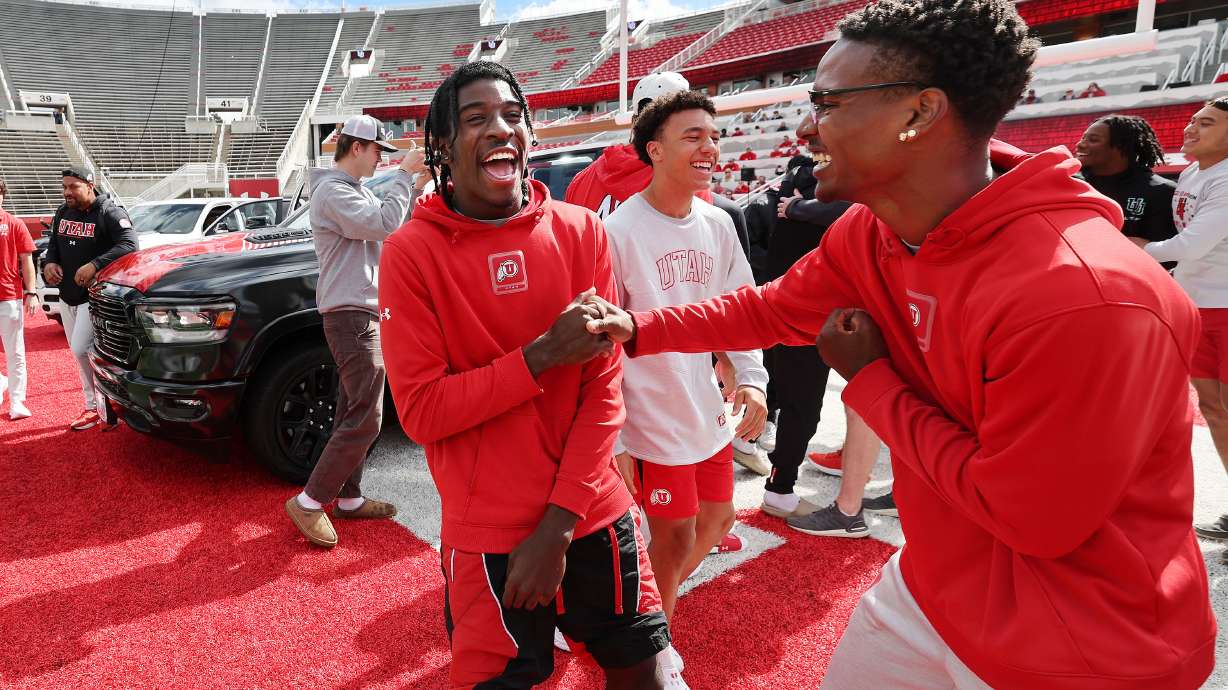 Utah Utes Daidren Zipperer, left, and C.J. Blocker celebrate getting a Dodge truck given to each player on the team by the Crimson Collective during an NIL announcement at Rice-Eccles Stadium in Salt Lake City on Wednesday, Oct. 4, 2023.